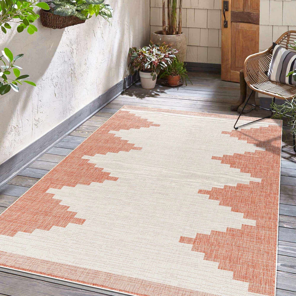 Peach Aztec-inspired outdoor rug in a furnished room